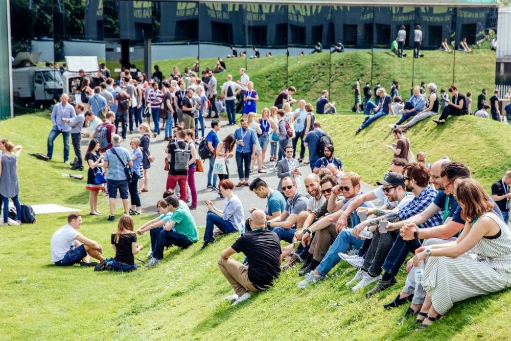 UX London attendees relax on the lawns outside and enjoy the sunshine.