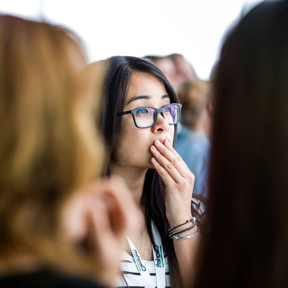 A UX London attendee looks at something off camera with interest.